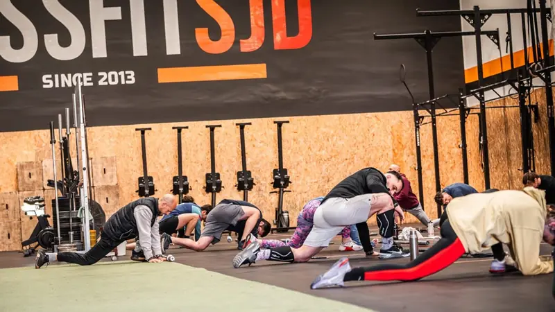 Escalfament de mobilitat de tot el grup sota el rètol «CrossFit SJD since 2013»