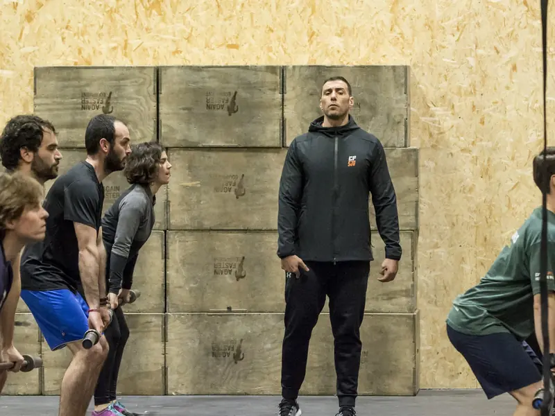 Un coach supervisa de prop un grup que treballa amb manuelles