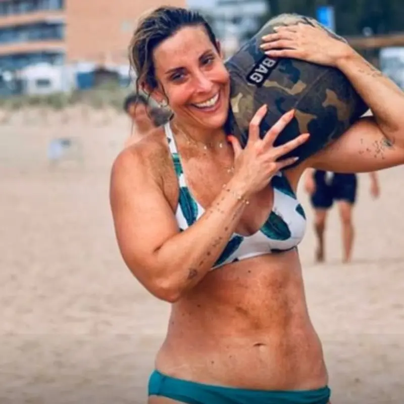 Vicky entrenant a la platja amb un sac a l'espatlla